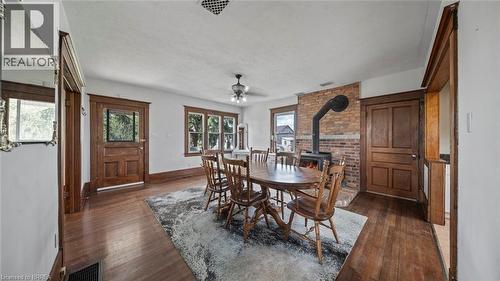 Interior space featuring wood-finish flooring, a brick accent wall, and a wood-burning stove - 3211 Highway 3, Jarvis, ON - Indoor Photo Showing Dining Room