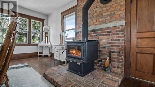 Wood-burning stove with a brick hearth and exposed brick wall - 3211 Highway 3, Jarvis, ON - Indoor Photo Showing Other Room With Fireplace