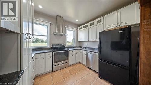 U-shaped kitchen featuring white cabinetry, dark countertops, and tile flooring - 3211 Highway 3, Jarvis, ON - Indoor Photo Showing Kitchen