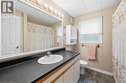 Bathroom featuring a vanity with an integrated sink, a dark countertop, and lower cabinetry - 
