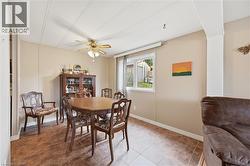 Dining space featuring wood-finish tile flooring, a window offering exterior views, and a ceiling fan with integrated lighting - 