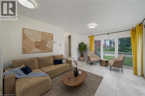 Living area featuring white walls, recessed ceiling lighting, light-toned tile flooring, and a large window overlooking the exterior - 7332 Twenty Road E, Glanbrook, ON - Indoor Photo Showing Living Room