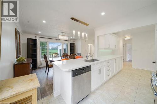 Kitchen featuring white cabinetry, light-toned tiled flooring, and a stainless steel dishwasher - 7332 Twenty Road E, Glanbrook, ON - Indoor Photo Showing Kitchen