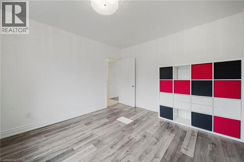 Light wood-finish flooring with white baseboards throughout - 7332 Twenty Road E, Glanbrook, ON - Indoor Photo Showing Other Room