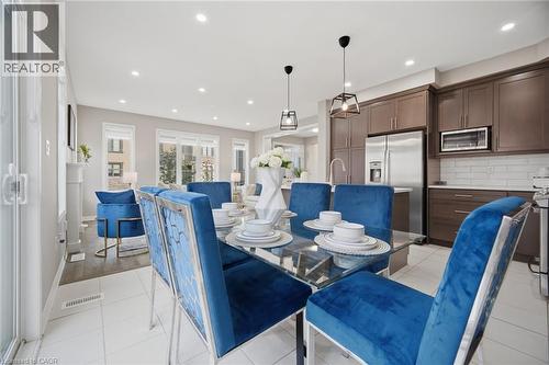 Open-concept interior featuring wood-finish flooring, recessed lighting, and a modern kitchen with stainless steel appliances - 542 Boyd Lane, Milton, ON - Indoor Photo Showing Dining Room