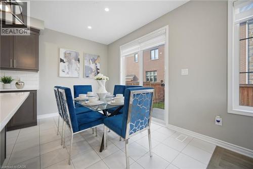 Dining area featuring a sliding glass patio door, a large window, recessed lighting, and tile flooring - 542 Boyd Lane, Milton, ON - Indoor Photo Showing Dining Room