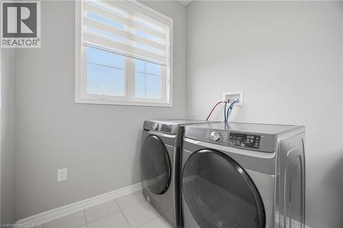 Functional utility space featuring a window with privacy blinds, light grey wall paint, and white baseboards - 542 Boyd Lane, Milton, ON - Indoor Photo Showing Laundry Room