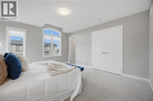 Carpeted bedroom featuring two large windows, including an arched window, and a flush-mount ceiling light - 542 Boyd Lane, Milton, ON - Indoor Photo Showing Bedroom