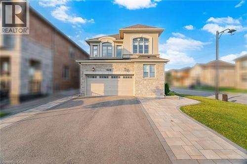 Stone facade residence featuring a two-car garage, paved driveway, and paver stone walkway - 542 Boyd Lane, Milton, ON - Outdoor