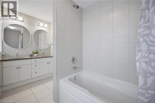 Bathroom featuring a white tiled bath and shower combination with chrome fixtures - 542 Boyd Lane, Milton, ON - Indoor Photo Showing Bathroom