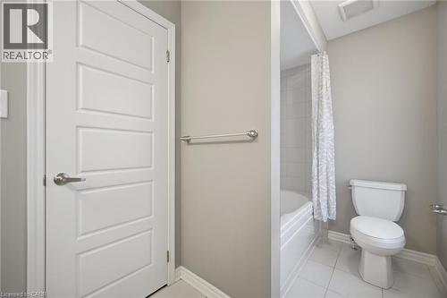 Four-panel interior door with brushed nickel hardware, white baseboards, and a neutral wall color - 542 Boyd Lane, Milton, ON - Indoor Photo Showing Bathroom