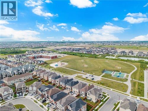 Extensive green space featuring a sports court, playground, and paved walking paths - 542 Boyd Lane, Milton, ON - Outdoor With View