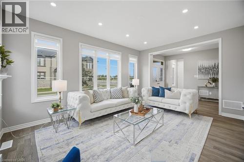 Spacious living area featuring large windows, recessed lighting, wide plank wood-finish flooring, and crisp white trim - 542 Boyd Lane, Milton, ON - Indoor Photo Showing Living Room