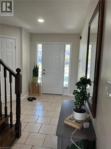 Entryway featuring ceramic tile flooring, a white paneled front door with sidelights, recessed lighting, and a dark wood staircase with balusters - 1367 Upper Paradise Road, Hamilton, ON - Indoor Photo Showing Other Room