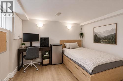Compact living space featuring wood-finish flooring, white walls, and recessed lighting - 74 Royal Avenue, Hamilton, ON - Indoor Photo Showing Bedroom