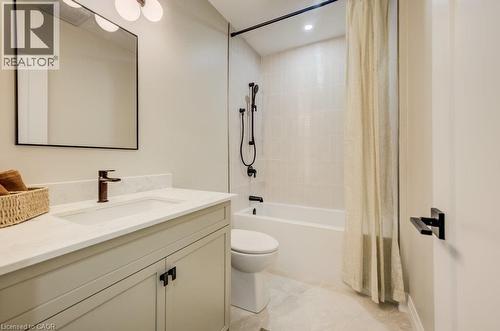 Modern bathroom featuring a light-toned vanity with a rectangular undermount sink, a dark bronze faucet, and a quartz countertop - 210 Heritage Drive Unit# Main, Kitchener, ON - Indoor Photo Showing Bathroom