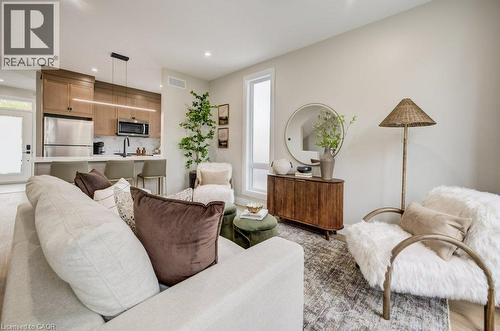 Open-concept living space featuring a modern kitchen with wood-finish cabinetry and stainless steel appliances - 210 Heritage Drive Unit# Main, Kitchener, ON - Indoor Photo Showing Living Room