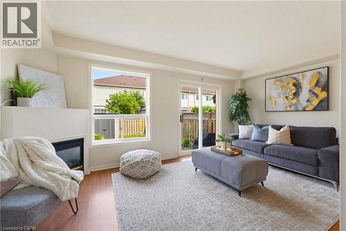Living area featuring wood-finish flooring, a built-in fireplace, and a large window - 4425 Peter Drive, Burlington, ON - Indoor Photo Showing Living Room