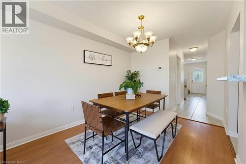 Dining area featuring wood-finish flooring, a brass chandelier, and light neutral wall colors - 4425 Peter Drive, Burlington, ON - Indoor Photo Showing Dining Room
