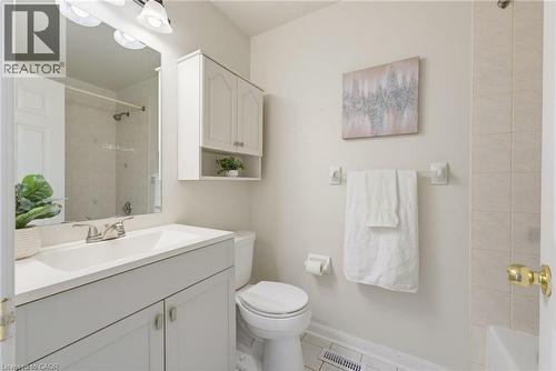 Bathroom featuring a white vanity with a single basin sink, white cabinetry, a wall-mounted medicine cabinet with open shelving, and tiled flooring - 4425 Peter Drive, Burlington, ON - Indoor Photo Showing Bathroom