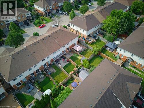 Aerial perspective highlighting a residential community with townhomes featuring brown shingle roofs, private fenced backyards, and paved patios - 4425 Peter Drive, Burlington, ON - Outdoor With View