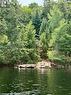 Cottage porch peeking out as you arrive - 50 Cache Lake Apl1322, South Algonquin, ON  - Outdoor With Body Of Water 