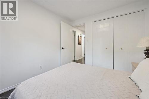 White interior walls with contrasting dark wood-finish flooring - 600 White Elm Boulevard Unit# 9, Waterloo, ON - Indoor Photo Showing Bedroom