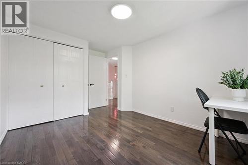 Room featuring dark wood-finish flooring, white baseboards, and a white ceiling with a flush-mount light fixture - 600 White Elm Boulevard Unit# 9, Waterloo, ON - Indoor