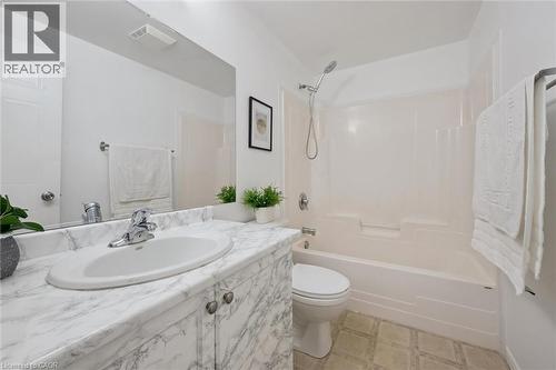 Full bathroom featuring a vanity with a white marble-patterned countertop, integrated sink, and an expansive wall mirror - 600 White Elm Boulevard Unit# 9, Waterloo, ON - Indoor Photo Showing Bathroom