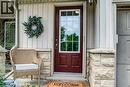 Entryway featuring a maroon paneled door with glass inserts, stone façade accents, vertical siding, and an overhead light fixture - 175 David Bergey Drive Unit# P86, Kitchener, ON  - Outdoor With Exterior 
