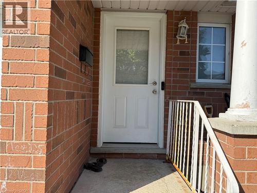 Entryway featuring a white door with a glass insert, brick exterior, and a side window with grid panes - 11 Hackberry Street Unit# 1, Kitchener, ON - Outdoor With Exterior