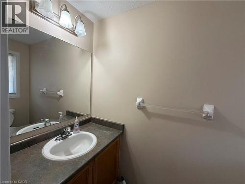 Vanity with an integrated white sink, chrome faucet, and dark countertop - 11 Hackberry Street Unit# 1, Kitchener, ON - Indoor Photo Showing Bathroom