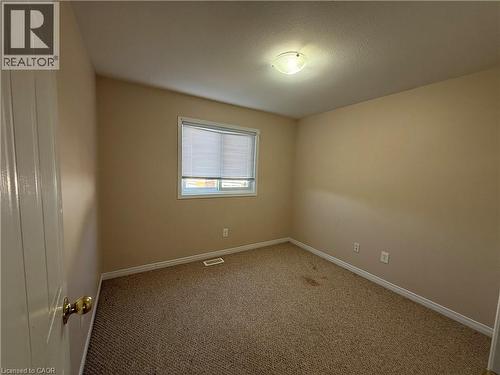 Bedroom featuring neutral carpeting, light beige wall paint, and white trim - 11 Hackberry Street Unit# 1, Kitchener, ON - Indoor Photo Showing Other Room