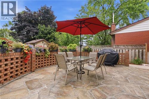 Stone patio featuring a permeable brick retaining wall with integrated planters - 76 Lower Canada Crescent, Kitchener, ON - Outdoor With Deck Patio Veranda