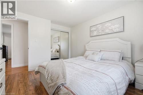 Light-filled room featuring wood-finish flooring and a closet with sliding mirrored doors - 76 Lower Canada Crescent, Kitchener, ON - Indoor Photo Showing Bedroom