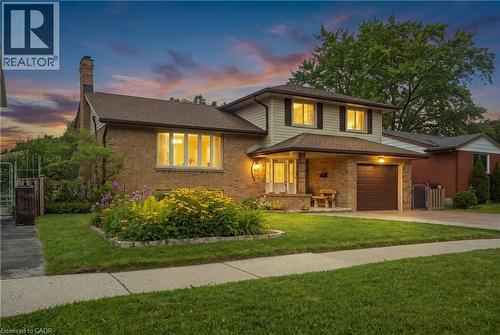 Brick and siding exterior featuring a covered entry, an attached garage, and a bay window - 76 Lower Canada Crescent, Kitchener, ON - Outdoor