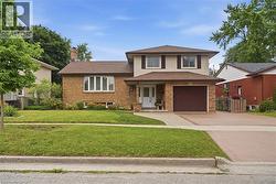 Two-story brick and siding residence featuring a concrete driveway and walkway - 