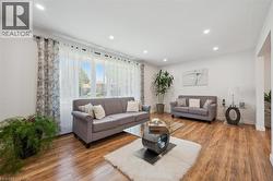 Bright living area featuring wood-finish flooring, recessed lighting, and white walls - 
