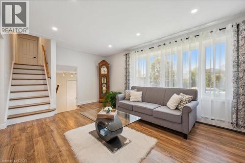 Living space featuring wood-finish flooring, recessed lighting, and a prominent staircase with wood treads and handrail - 76 Lower Canada Crescent, Kitchener, ON - Indoor Photo Showing Living Room