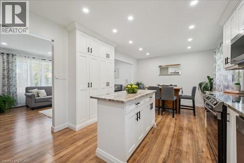 Bright kitchen featuring white shaker cabinetry, stainless steel appliances, a center island with countertop, and wood-finish flooring - 76 Lower Canada Crescent, Kitchener, ON - Indoor Photo Showing Kitchen