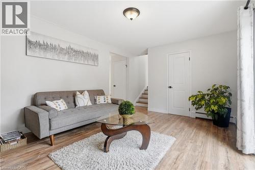 Bright living area featuring wood-finish flooring, white trim, and a ceiling-mounted light fixture - 76 Lower Canada Crescent, Kitchener, ON - Indoor Photo Showing Living Room