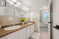 Double vanity featuring white cabinetry, integrated sinks, and chrome faucets - 