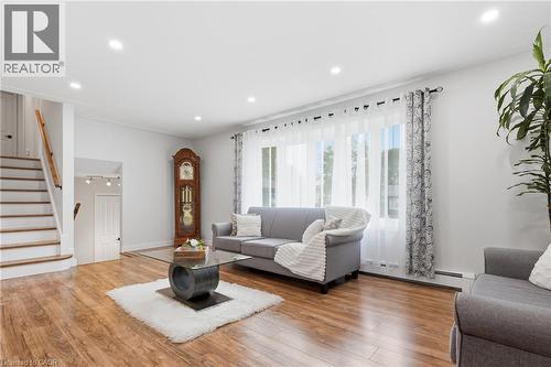 Bright living area featuring wood-finish flooring, recessed lighting, and a large window with sheer and patterned drapes - 76 Lower Canada Crescent, Kitchener, ON - Indoor Photo Showing Living Room