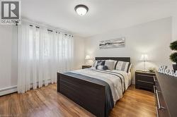 Bedroom with wood-finish flooring and neutral wall tones - 