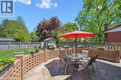 Stone patio featuring a curved brick privacy wall with decorative openwork - 