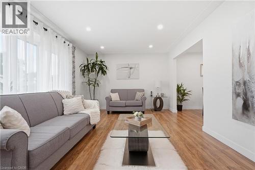 Living area featuring wood-finish flooring, recessed ceiling lighting, and expansive windows with sheer curtains - 76 Lower Canada Crescent, Kitchener, ON - Indoor Photo Showing Living Room