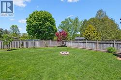 Expansive green lawn with a circular stone fire pit - 