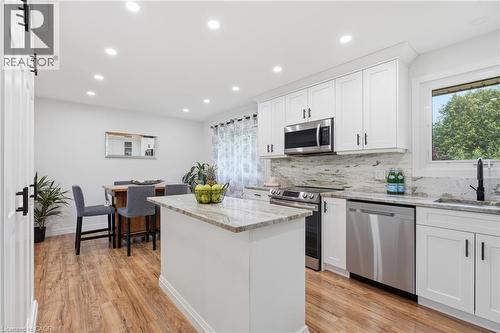 Kitchen featuring white shaker cabinetry, stainless steel appliances, granite countertops, and wood-finish flooring - 76 Lower Canada Crescent, Kitchener, ON - Indoor Photo Showing Kitchen With Upgraded Kitchen