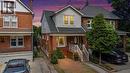 Brick facade home featuring a gabled roofline, front porch with white railings, and a paved driveway - 37 Park Row N, Hamilton, ON  - Outdoor 