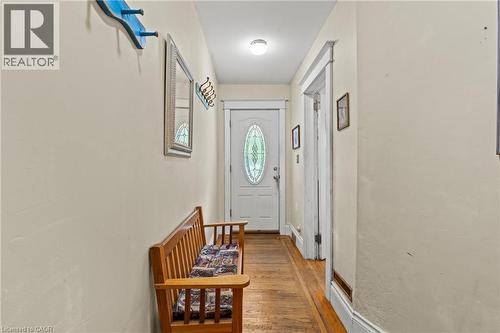 Entryway featuring a white door with an oval stained-glass insert, wood-finish flooring, and light-toned wall paint - 37 Park Row N, Hamilton, ON - Indoor Photo Showing Other Room